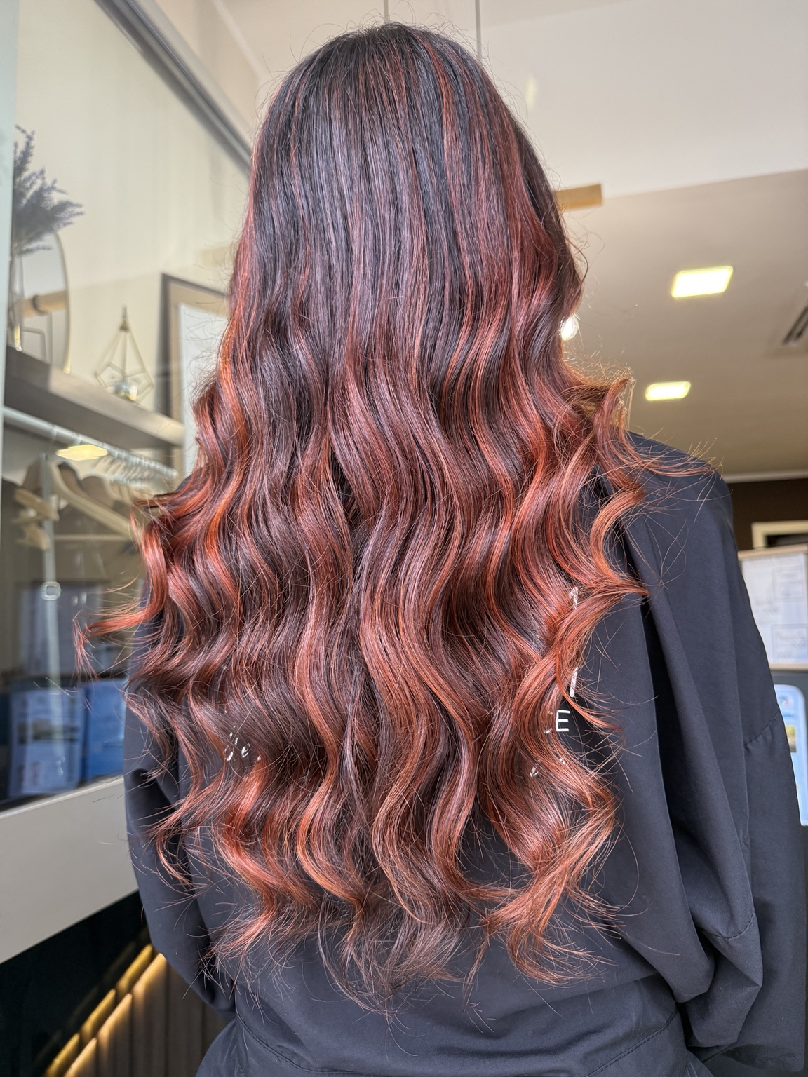 Capelli lunghi con riflessi rossi luminosi realizzati da GLAM